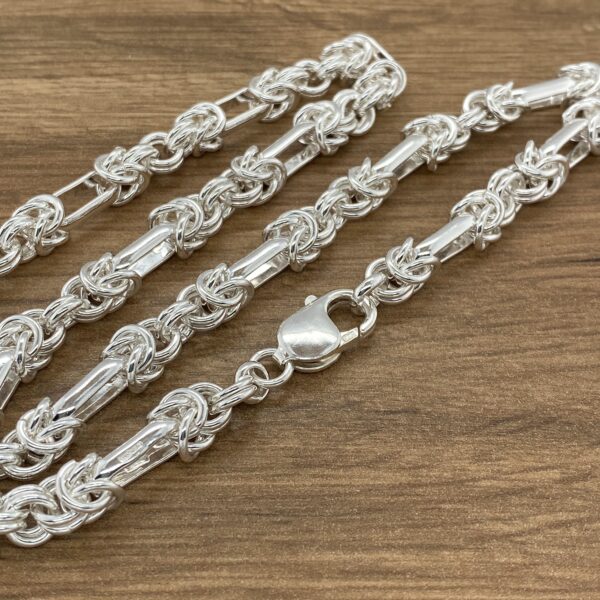 Silver rope chains on wood background.