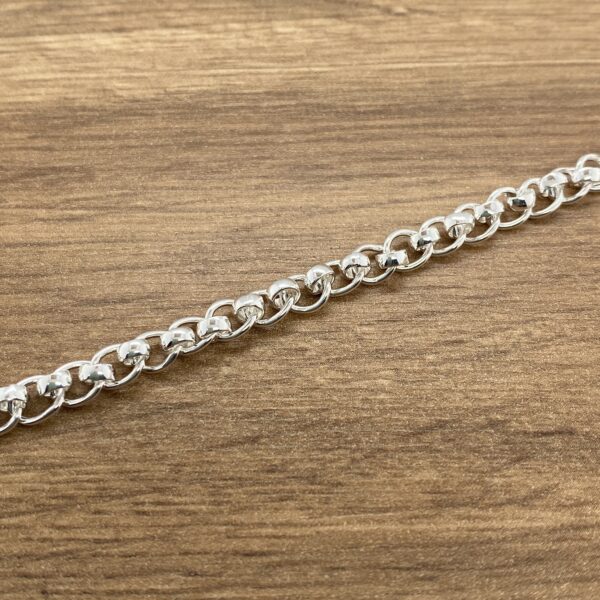 Silver chain bracelet on wood.