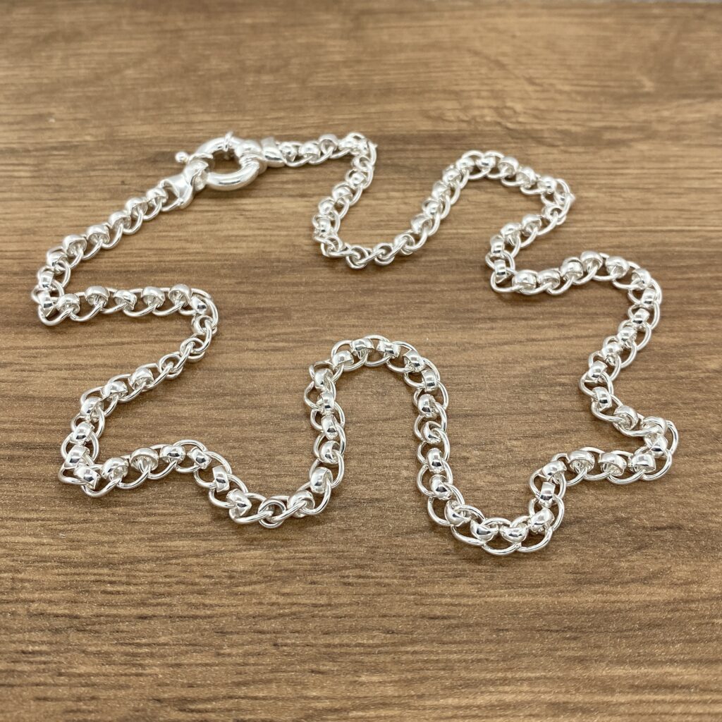 Silver beaded chain necklace on wood.