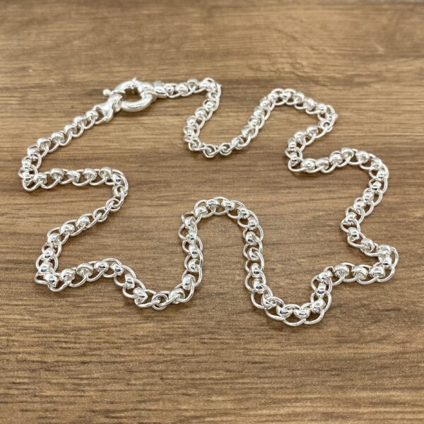 Silver beaded chain necklace on wood.