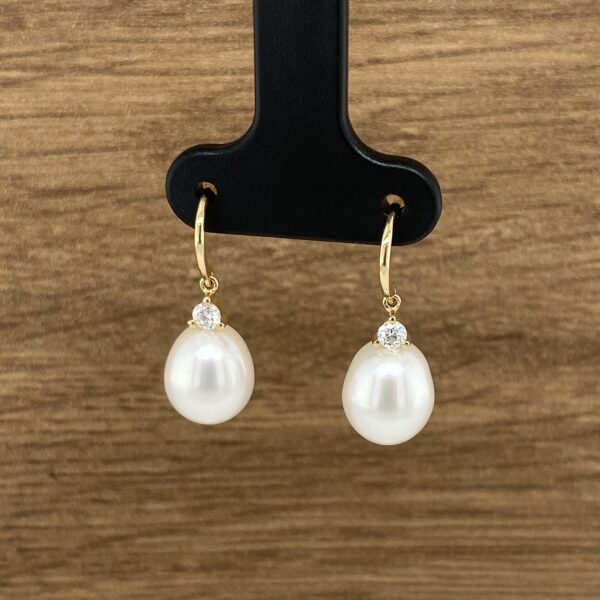 Gold pearl earrings with diamond accents.
