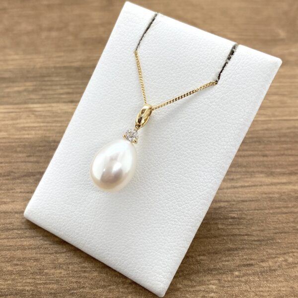 Elegant pearl and diamond pendant necklace.
