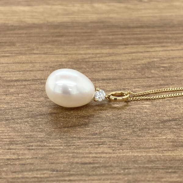 Gold pearl pendant with diamond.