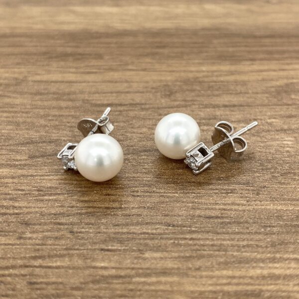 Pearl and diamond stud earrings.