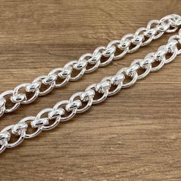 Silver chain necklace on wood.