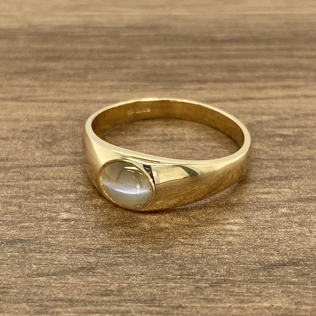 Gold signet ring with cabochon stone.