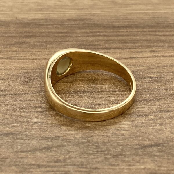 Gold ring with oval gemstone.