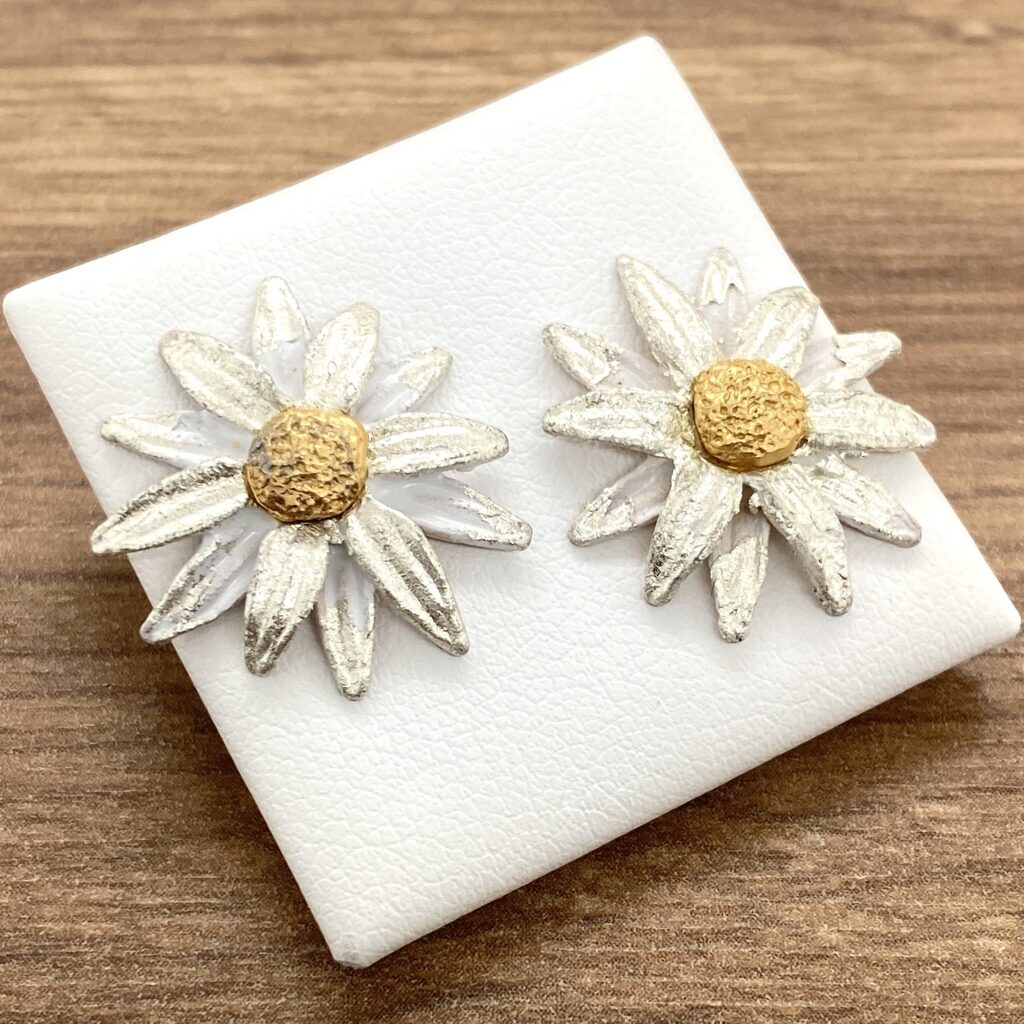 Silver and gold daisy earrings.