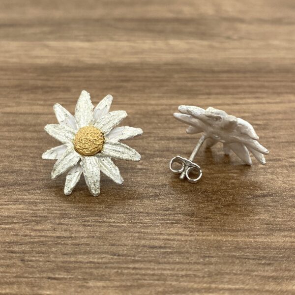 Silver daisy flower stud earrings.