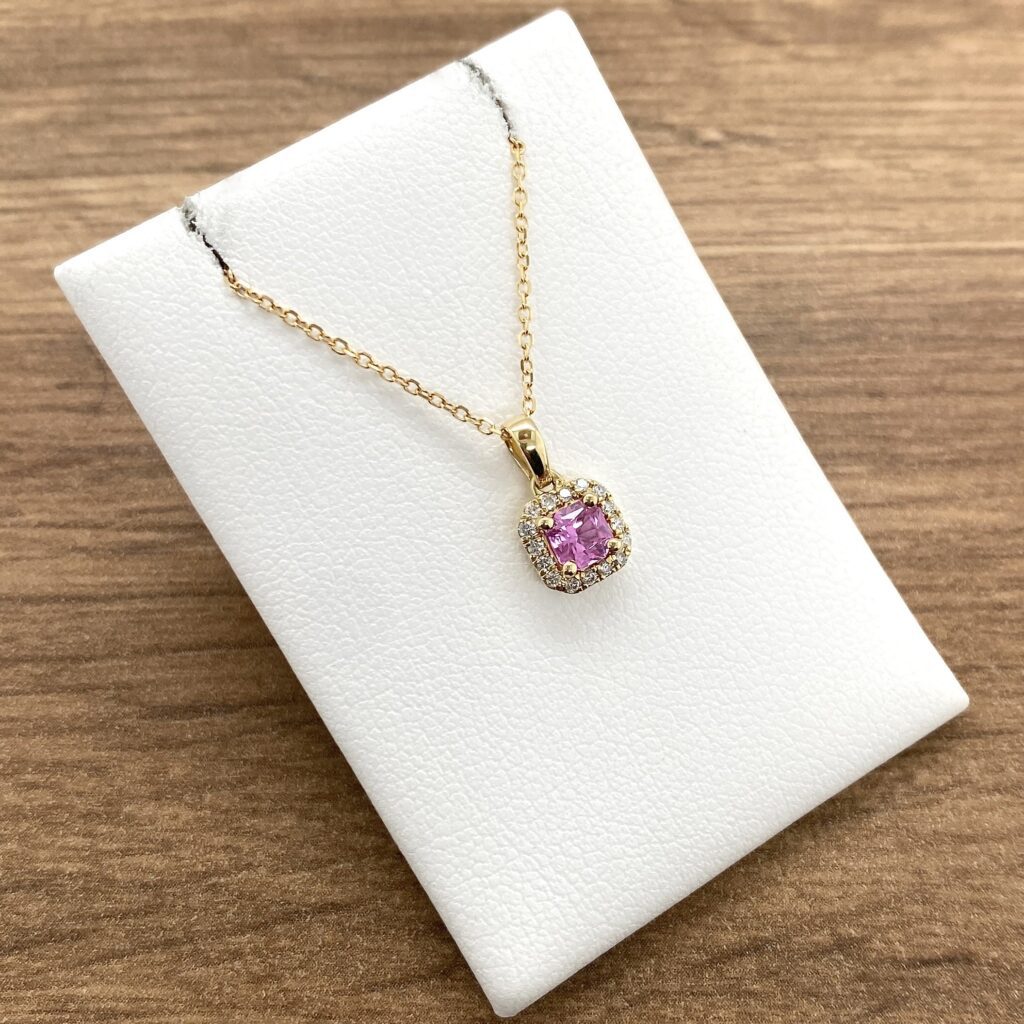 Pink sapphire and diamond pendant necklace.