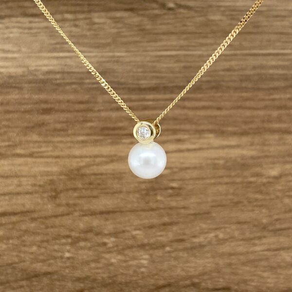 Gold pearl necklace with diamond.