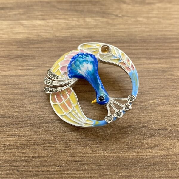 Circular peacock enamel brooch.