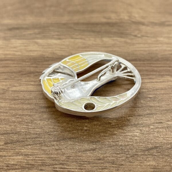 Silver bird brooch, yellow and blue enamel.