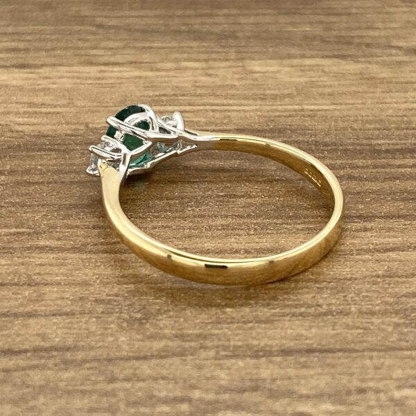 Gold ring with emerald and diamonds.