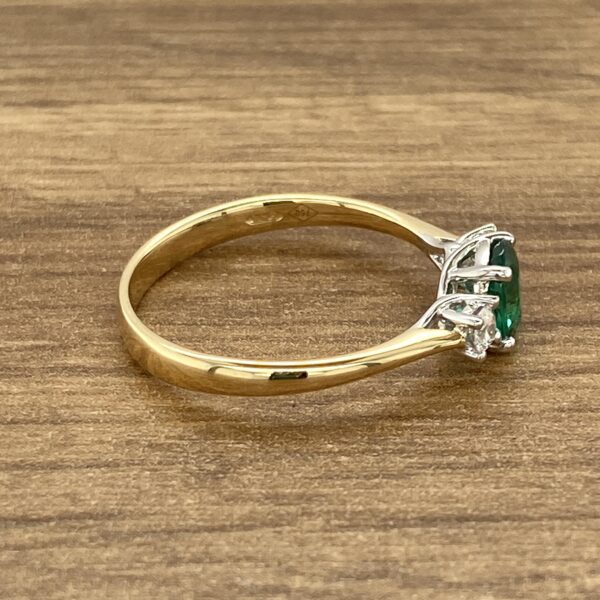 Gold ring with green gemstone and diamonds.
