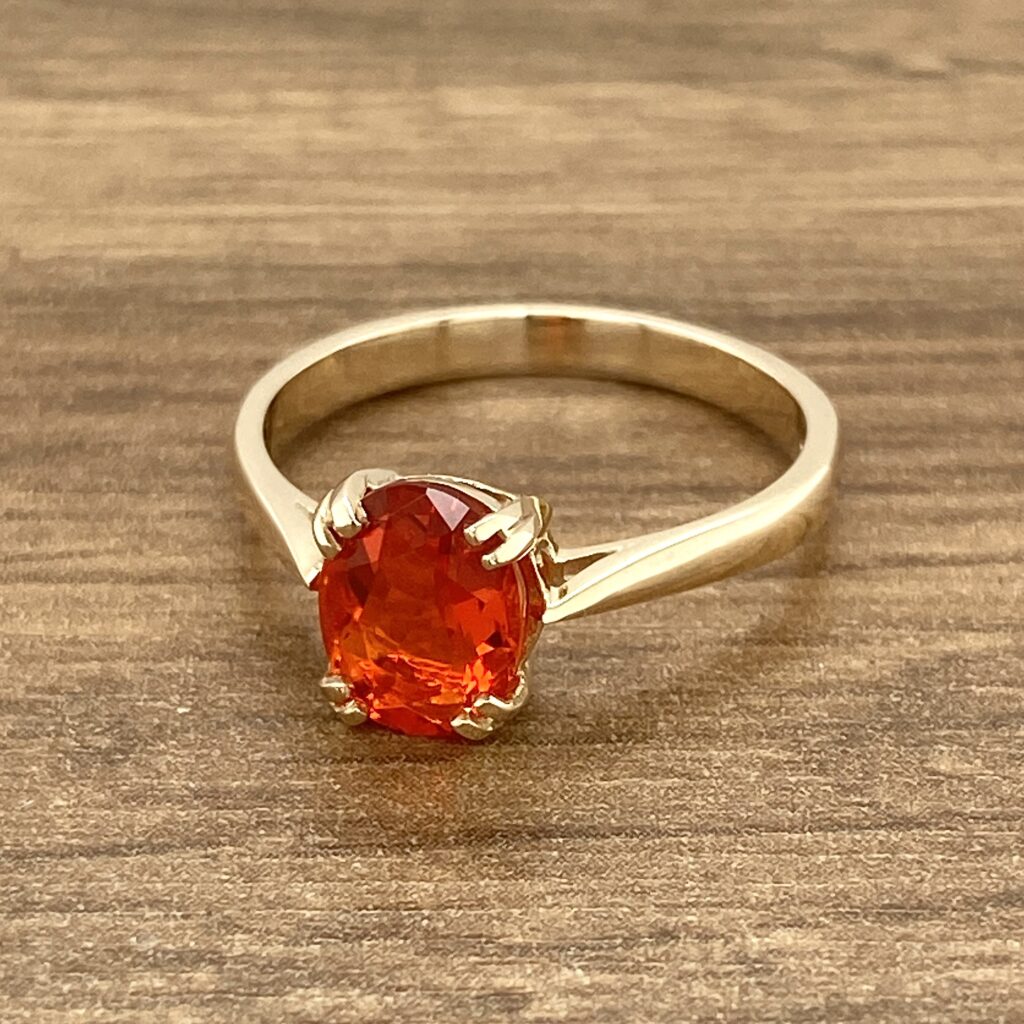 Gold ring with orange gemstone.