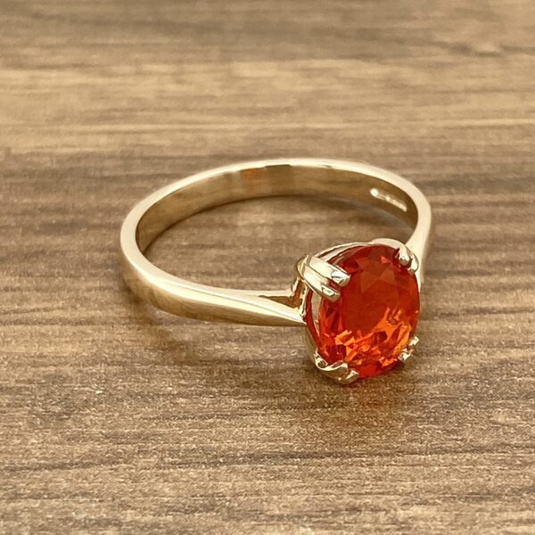 Gold ring with orange gemstone.