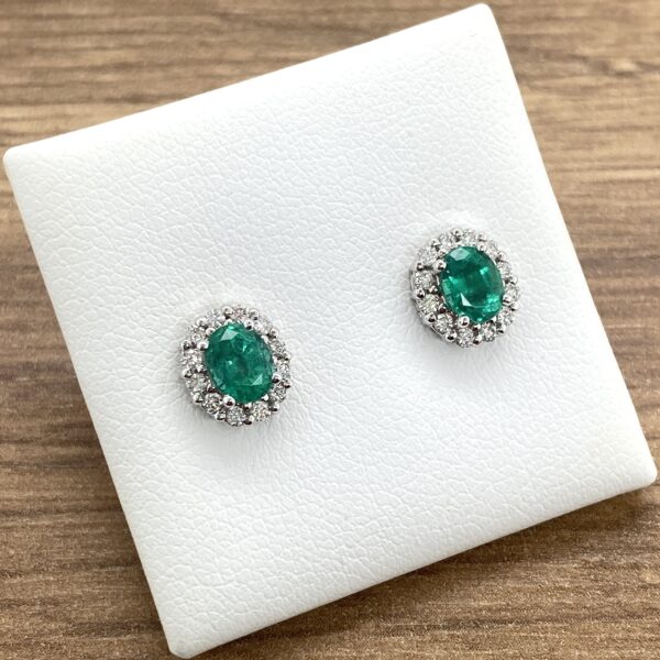 Emerald and diamond halo stud earrings.