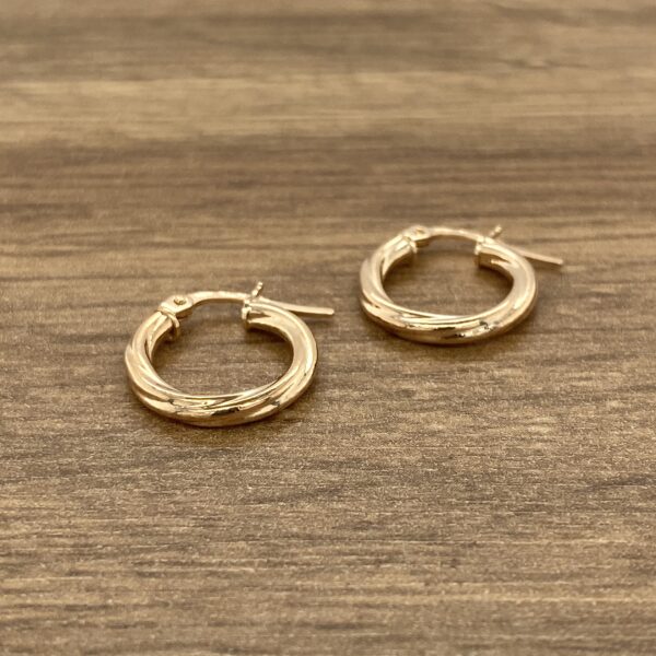 Gold twisted hoop earrings pair.