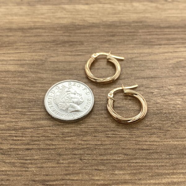 Pair of gold twisted hoop earrings.